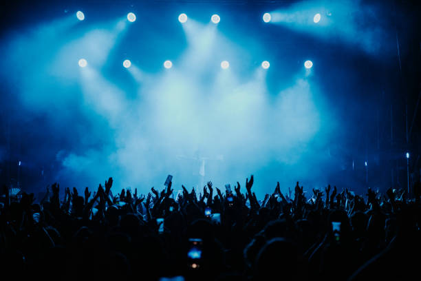 Crowd of people dancing at a music show in Barcelona in blue colour during the summer of 2022